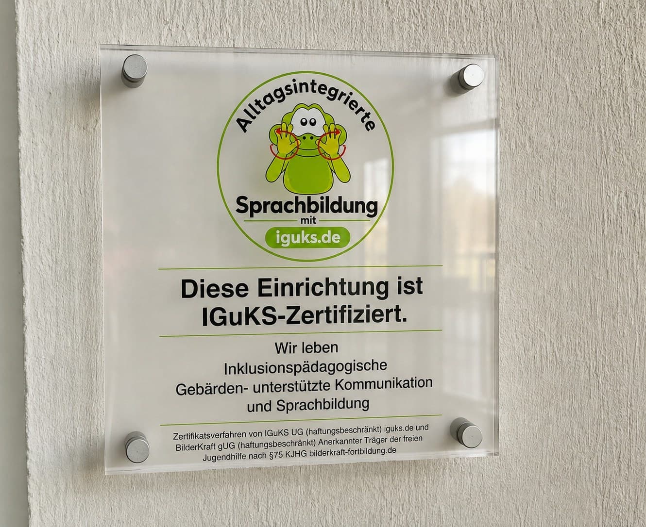 Acrylglas-Plakette an einer Wand mit dem Text: Diese Einrichtung ist IGuKS-Zertifiziert.